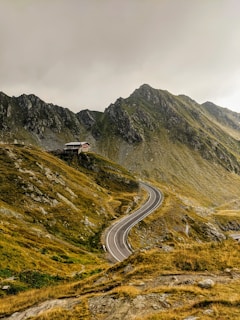 white car on road near green mountain during daytime