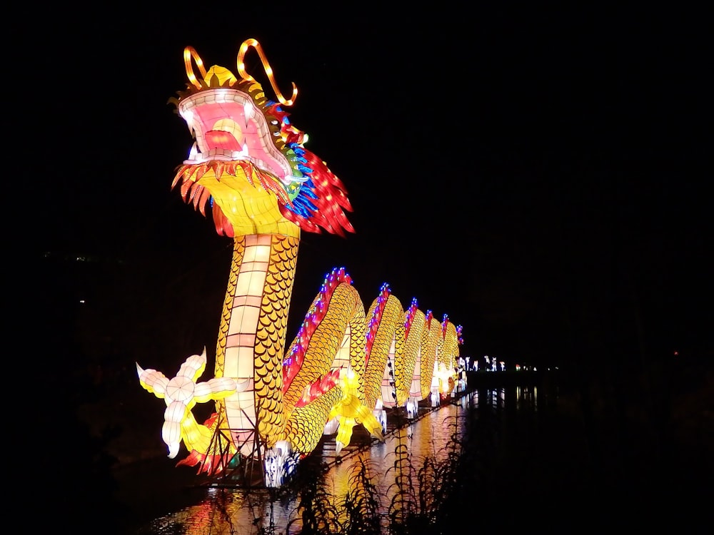 yellow and red dragon with lights on top of building