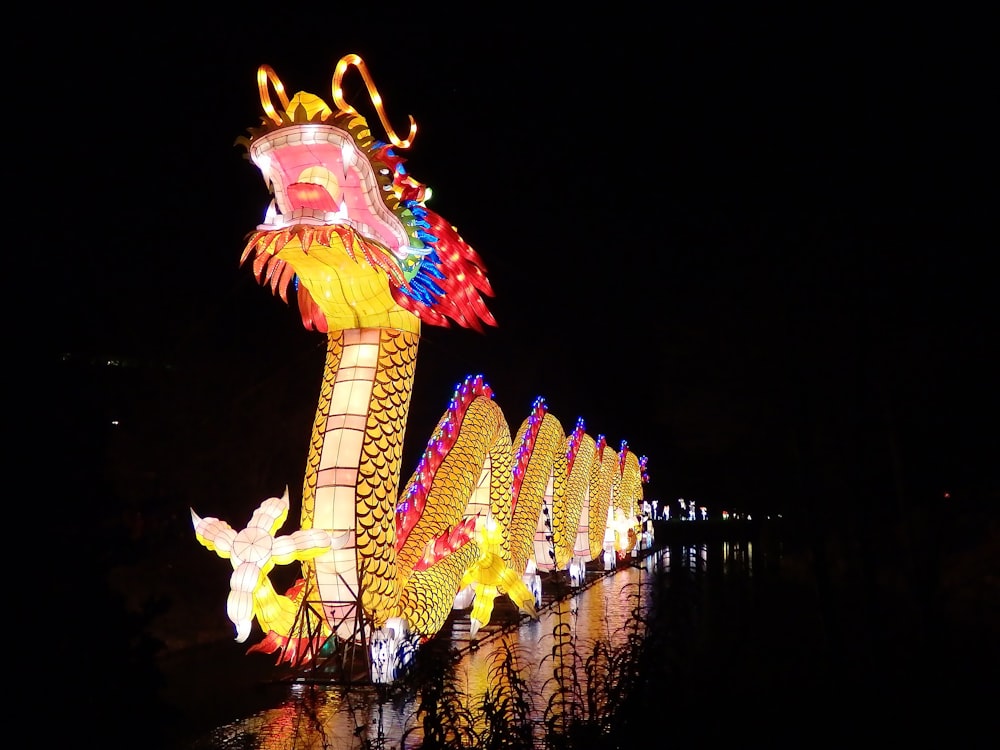 Gelber und roter Drache mit Lichtern auf dem Dach des Gebäudes