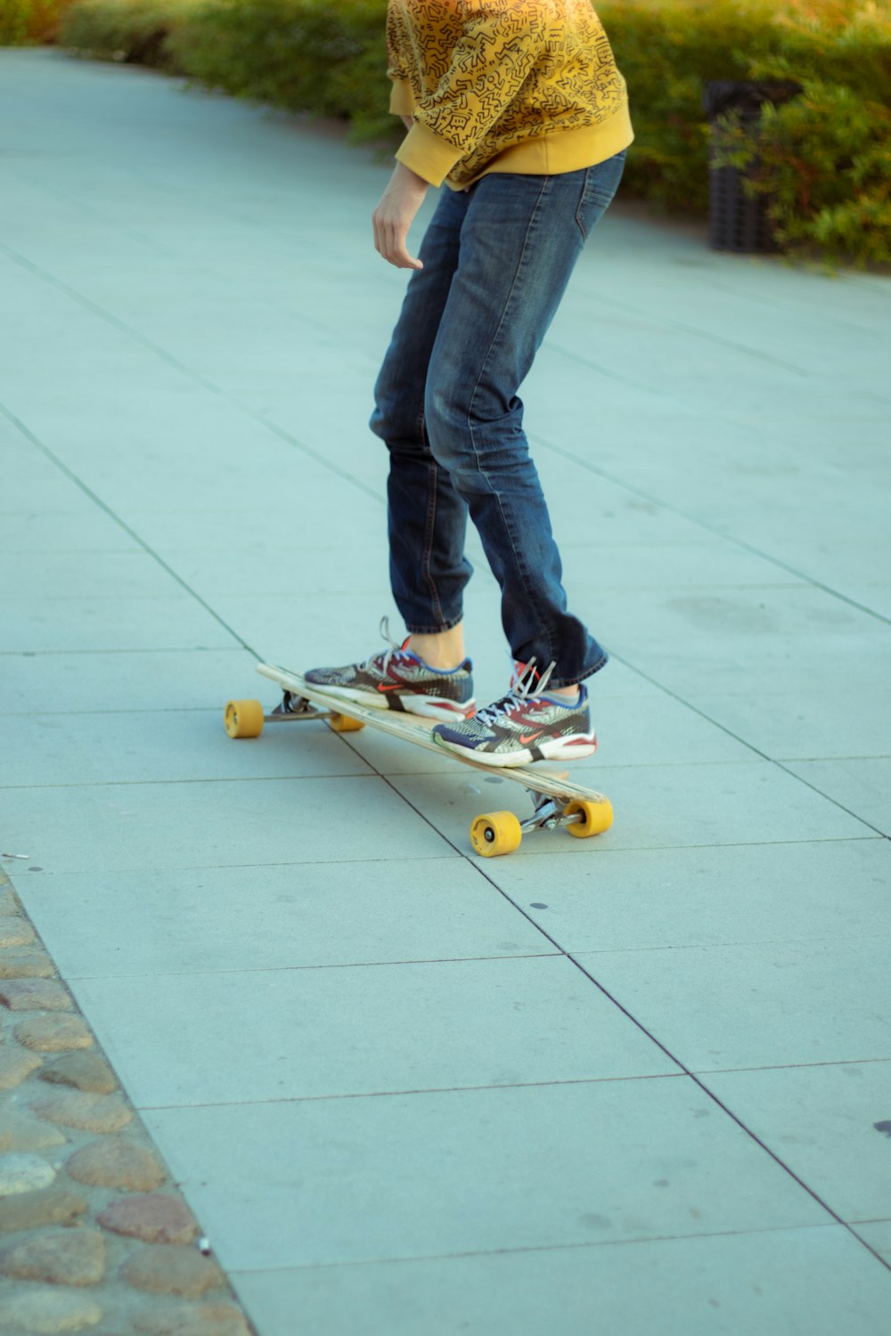 person in blue denim jeans and black and yellow skateboard