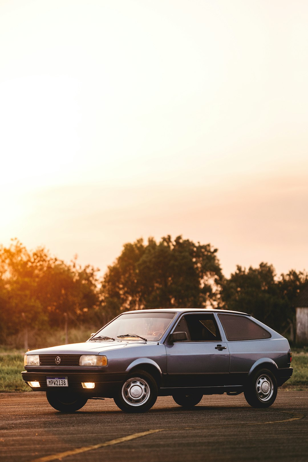 gray sedan on green grass field during daytime