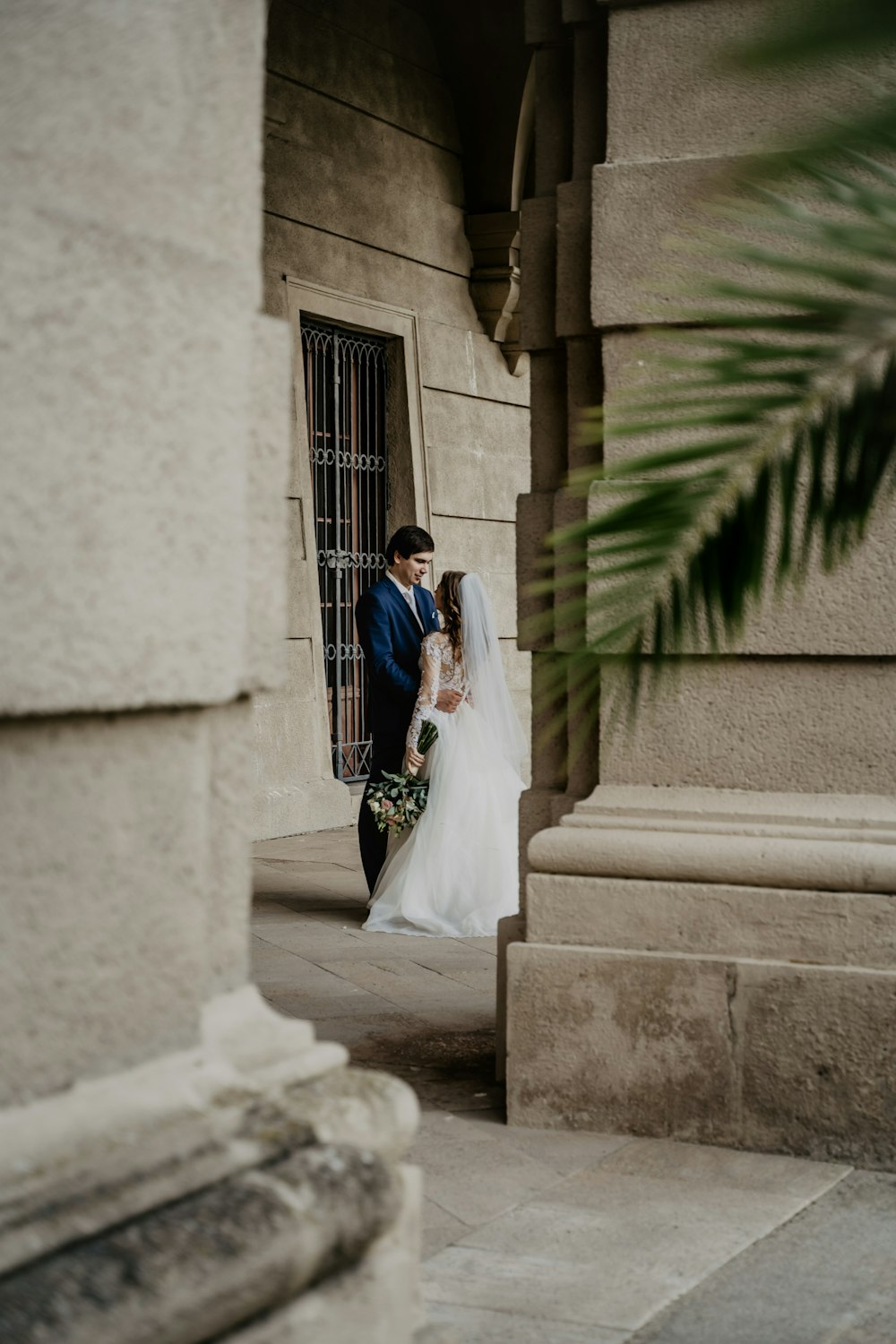 man and woman in wedding dress walking on sidewalk during daytime