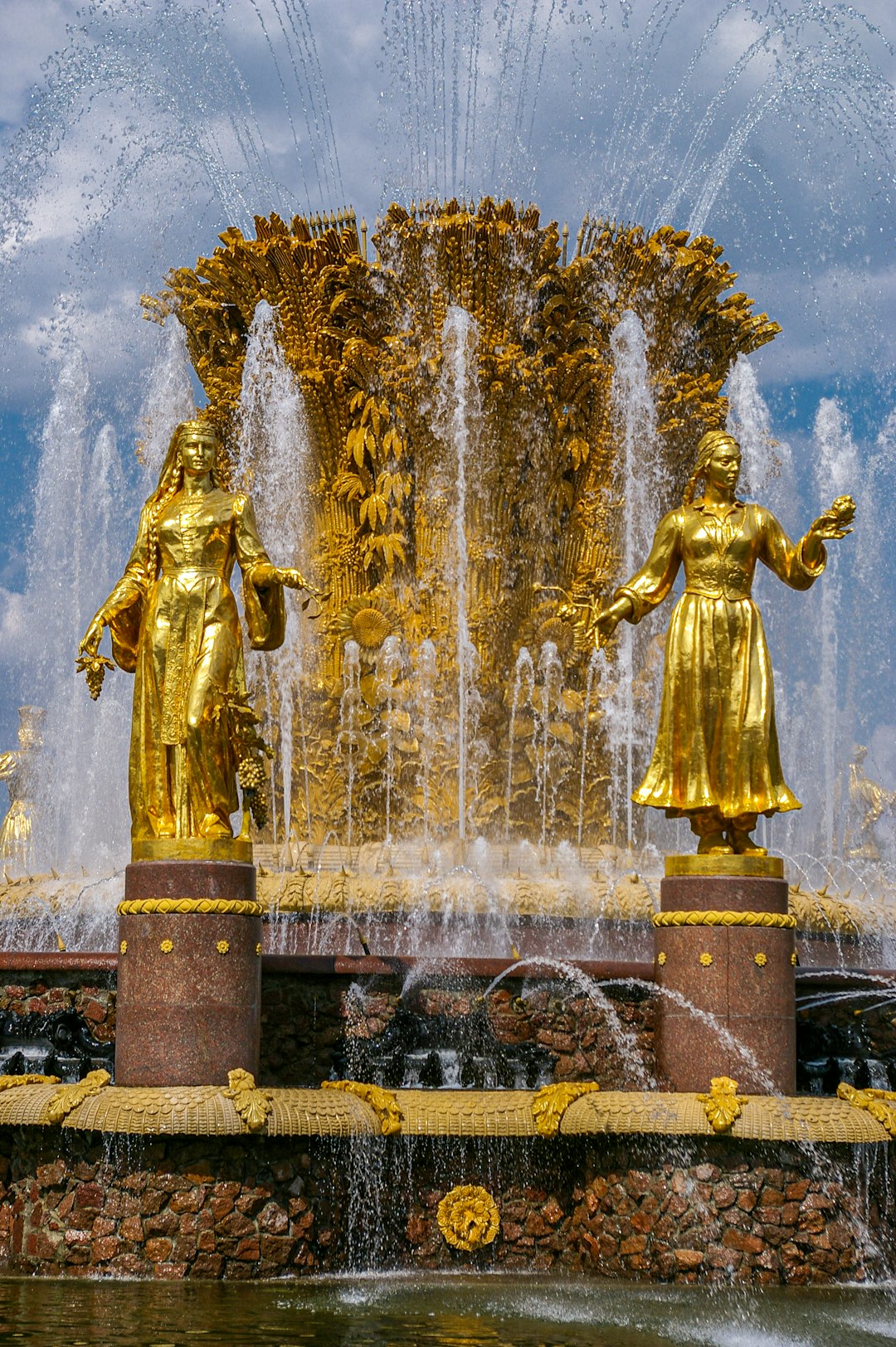 gold statue fountain during night time