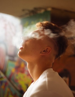 An artistic shot of vapor swirling in the air with soft natural light filtering through a window.