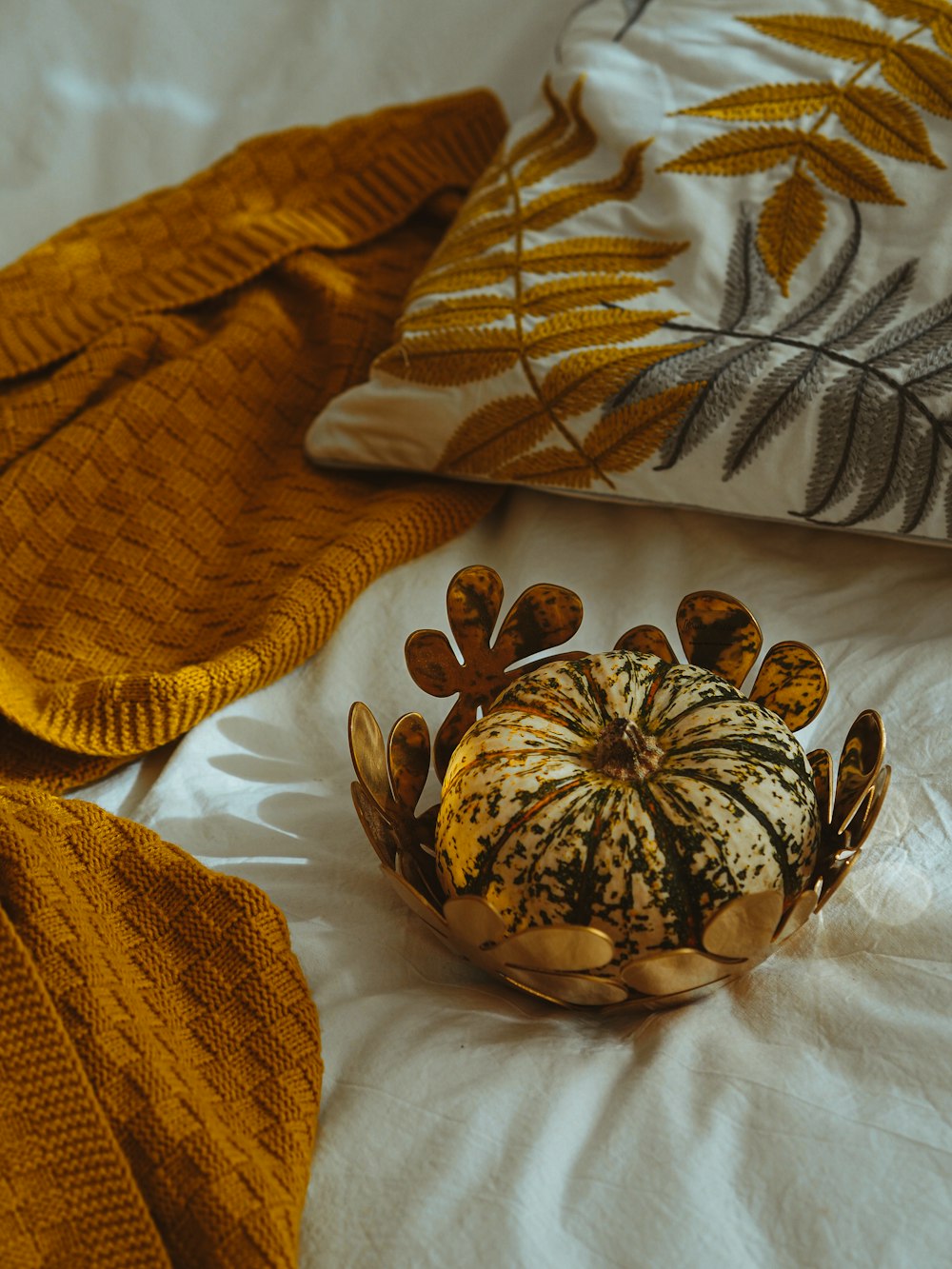 brown and black floral ceramic bowl on white textile