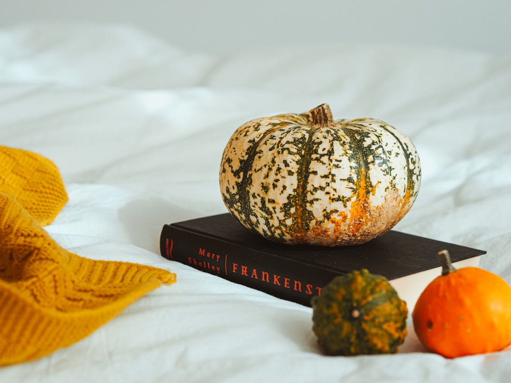 a couple of pumpkins sitting on top of a book