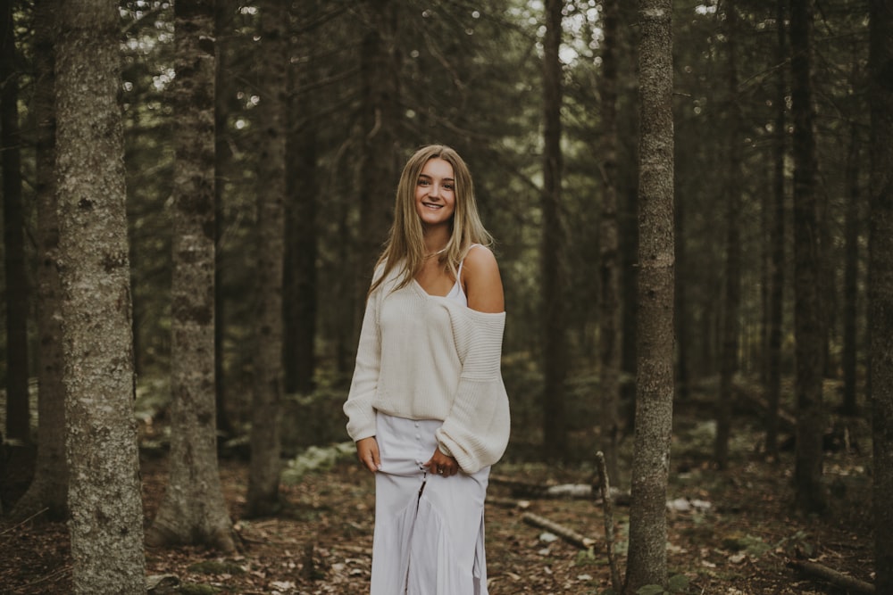 woman in white long sleeve dress standing in the woods