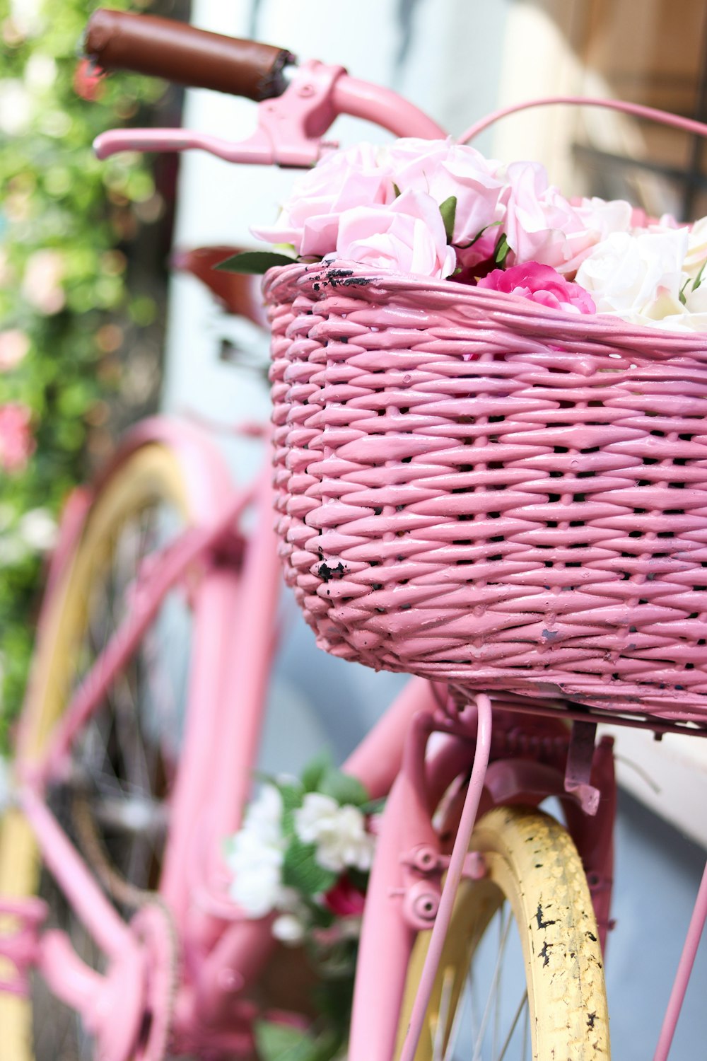 pink woven basket on yellow bicycle