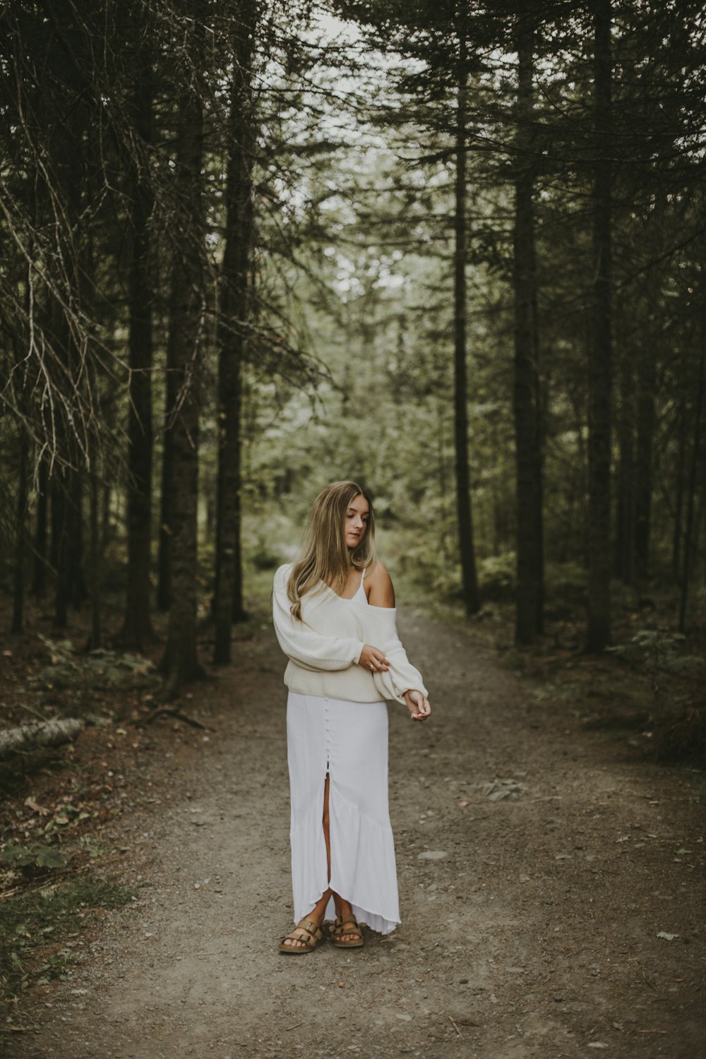 woman in white long sleeve dress standing in the woods