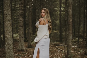 Clara Dawson smiling gently, framed by tall trees in a peaceful woodland.