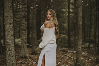 Clara Dawson smiling gently, framed by tall trees in a peaceful woodland.