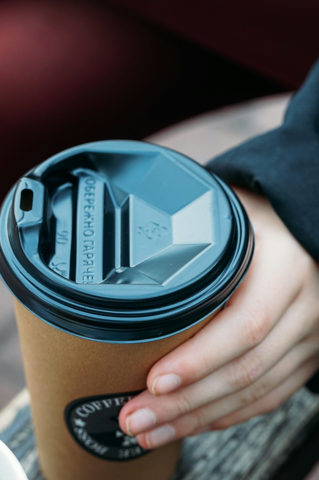 person holding black and brown coffee cup