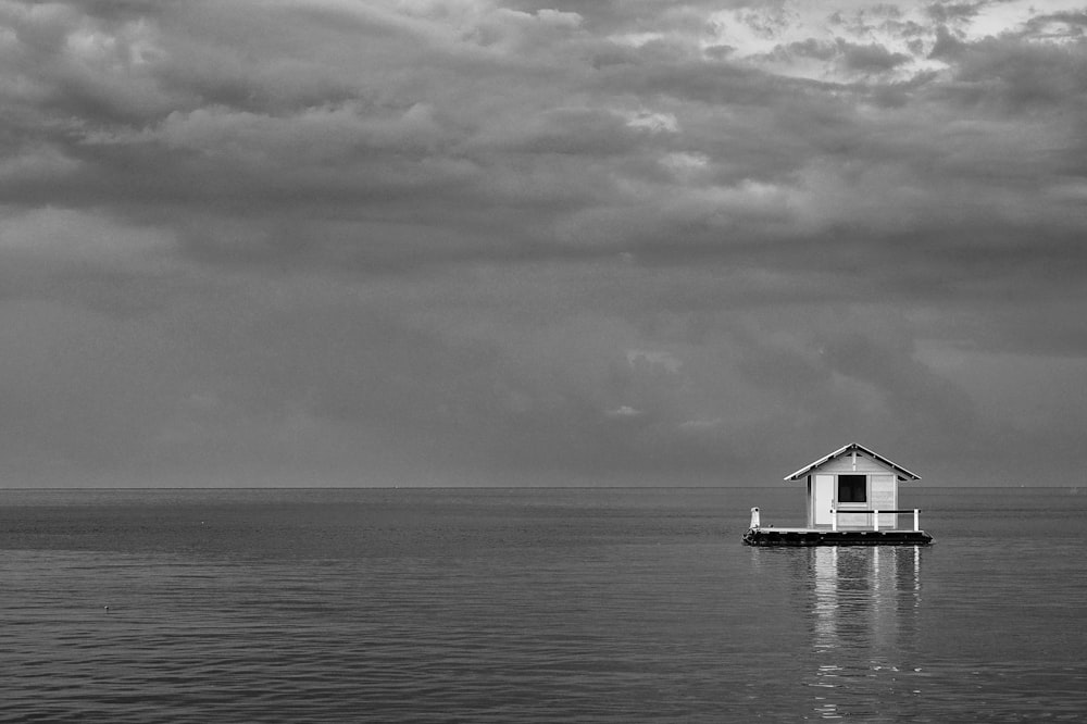 grayscale photo of house on body of water
