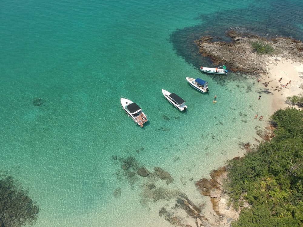 Vista aérea de un barco blanco en la orilla del mar durante el día