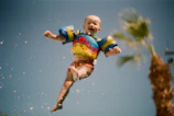 A playful pool scene with children enjoying the water, wearing éclat marin floatation gear.