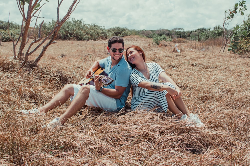 2 women sitting on brown grass field during daytime