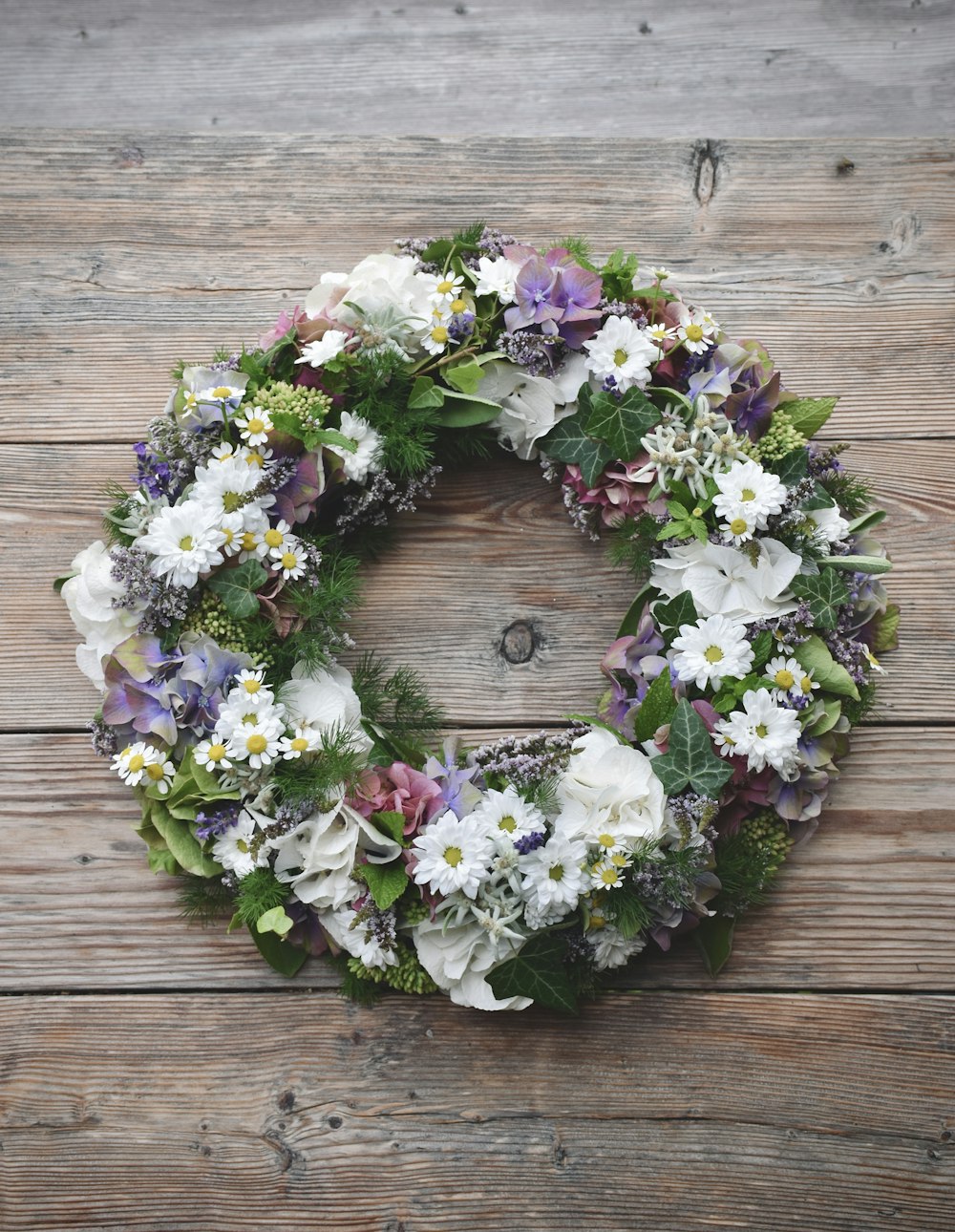 corona floral blanca, morada y verde