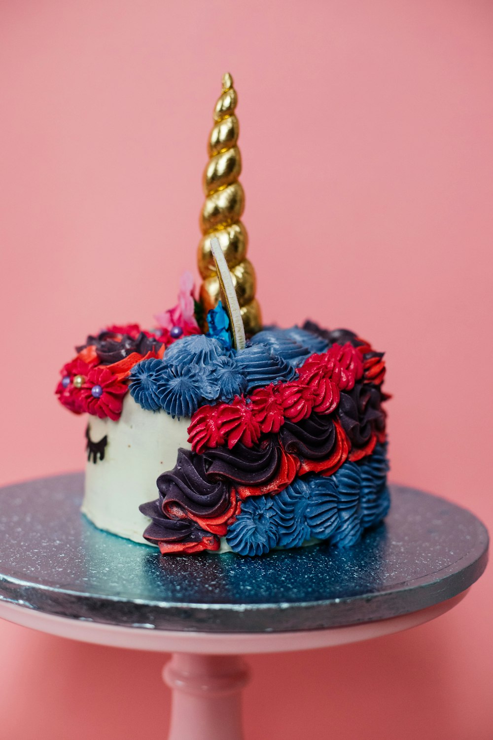 blue and red cake with red and gold ribbon