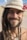 man in white hat and black beaded necklace