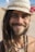 man in white hat and black beaded necklace