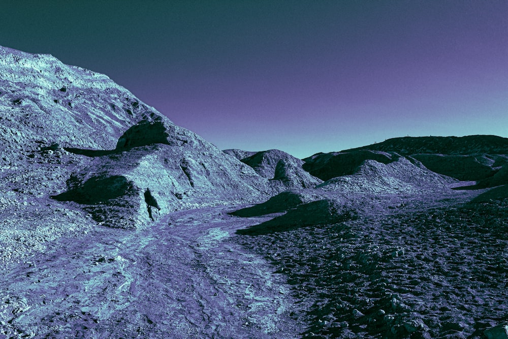 gray rocky mountain beside body of water during daytime