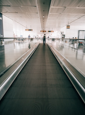 A moving walkway in a spacious airport terminal with travelers comfortably gliding along.