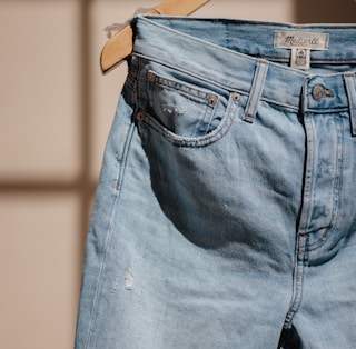 blue denim jeans on brown clothes hanger