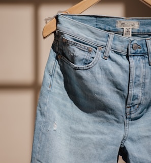 blue denim jeans on brown clothes hanger