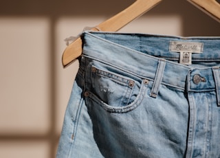 blue denim jeans on brown clothes hanger