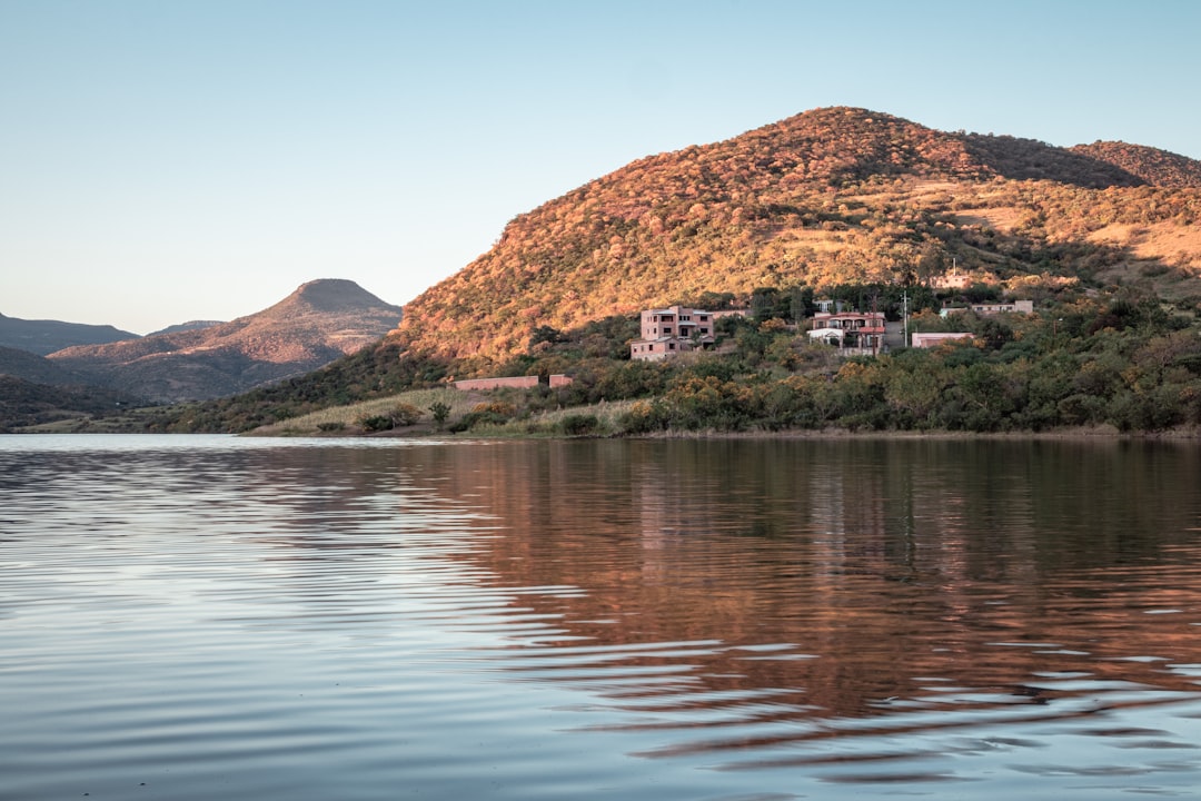 body of water near mountain during daytime