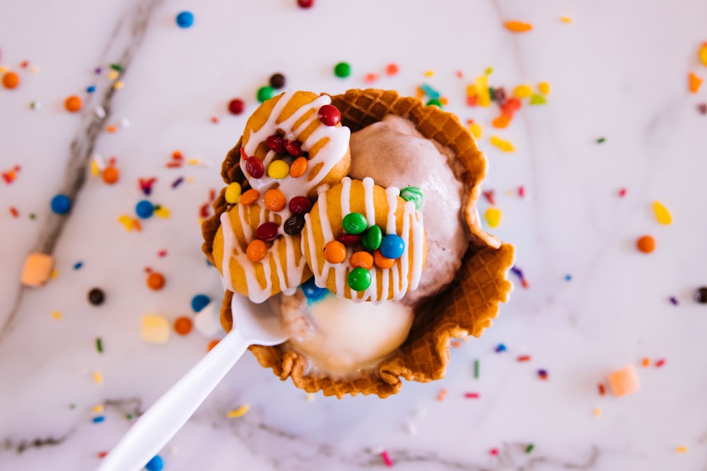 brown cupcake with white icing and sprinkles