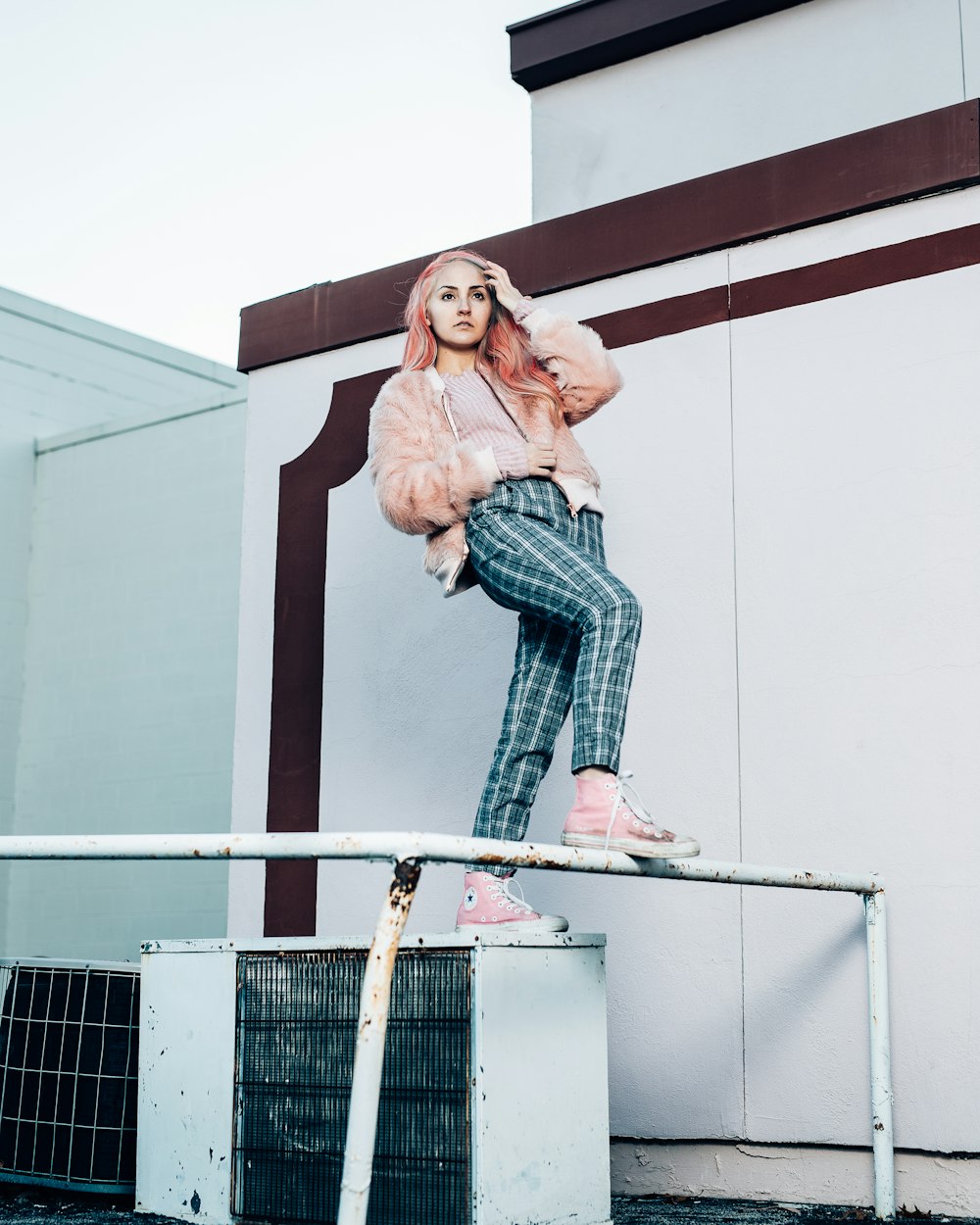 woman in blue denim jeans standing on white metal railings