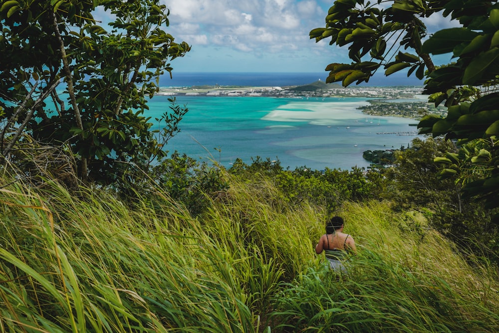 a person walking up a hill near a body of water