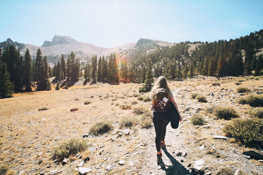 woman in black jacket standing on brown field during daytime