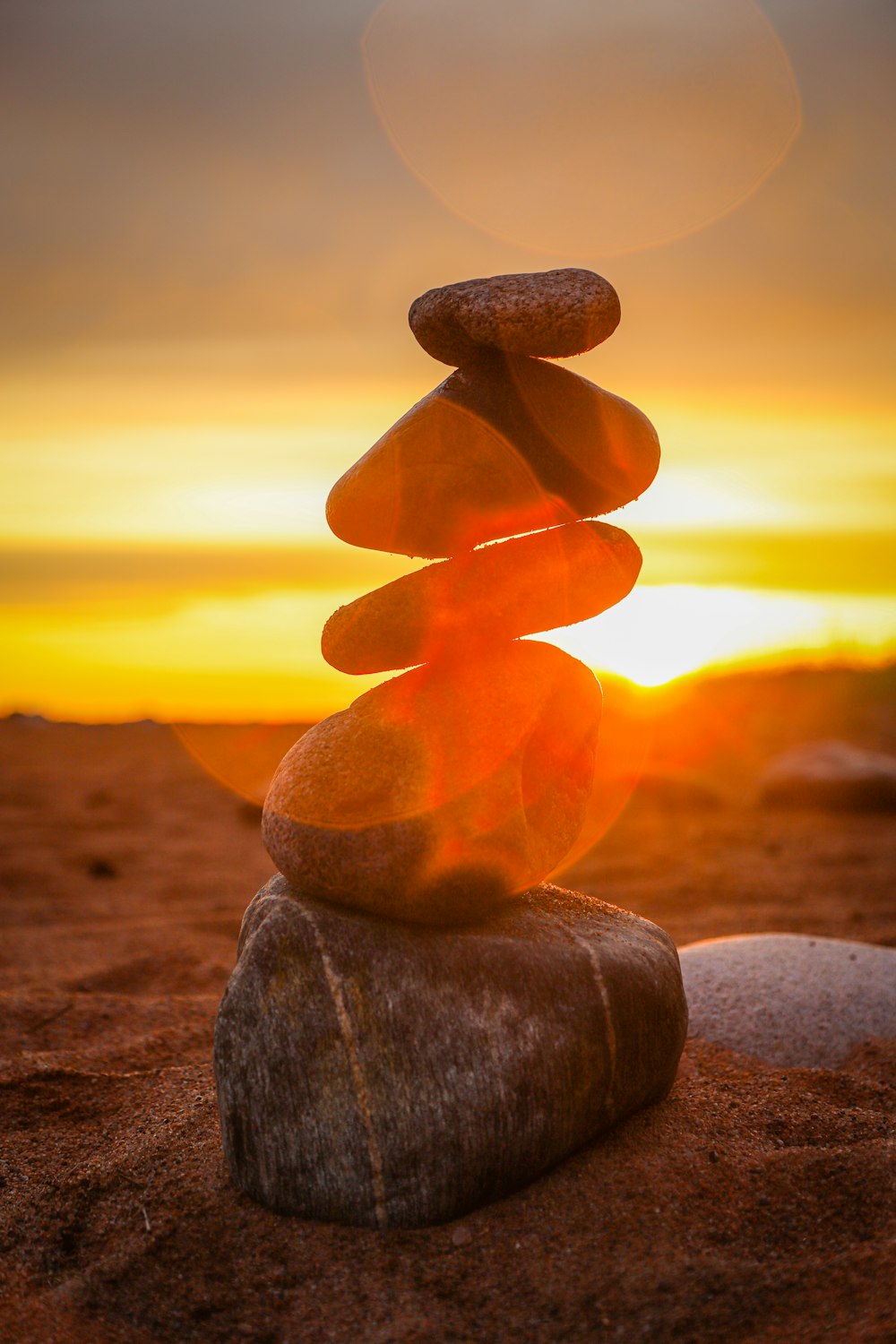 brown and gray stone on brown sand during sunset