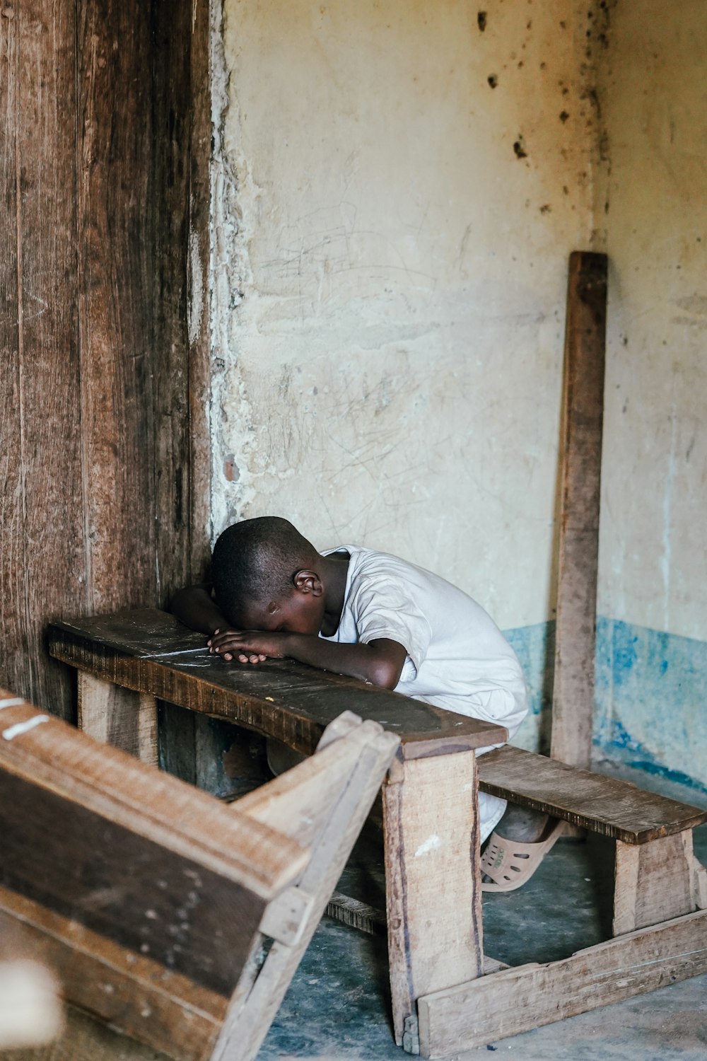 man in white shirt lying on brown wooden bed