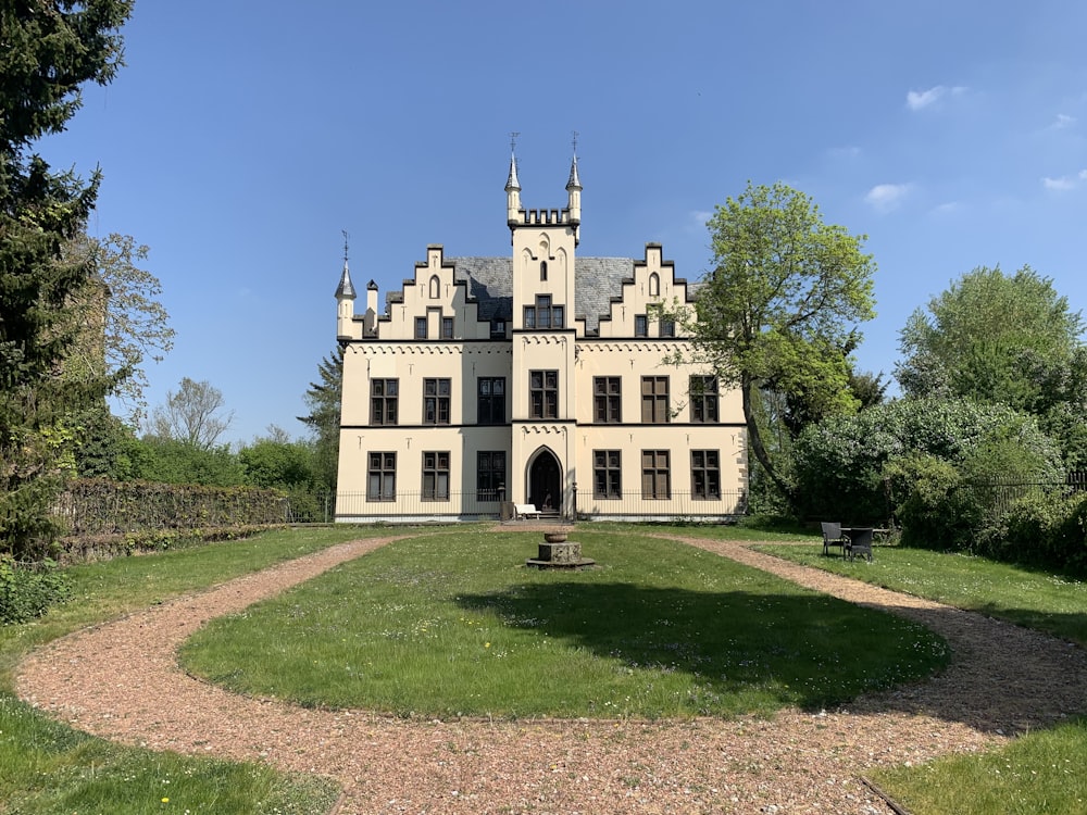 a large castle like building sitting on top of a lush green field