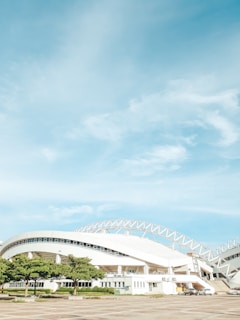 Sports facility constructed with timber frame and a four-pitched roof under bright sky.