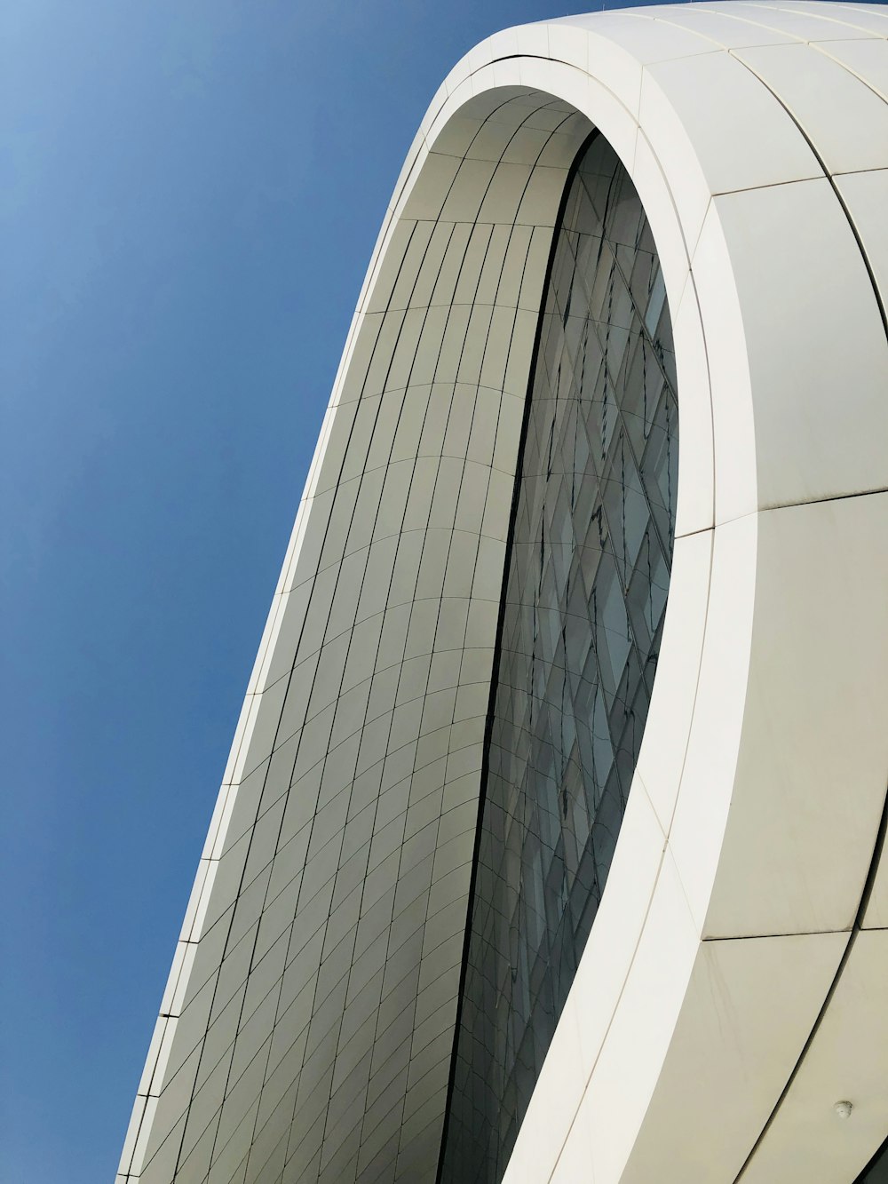 Weißes Betongebäude unter blauem Himmel tagsüber