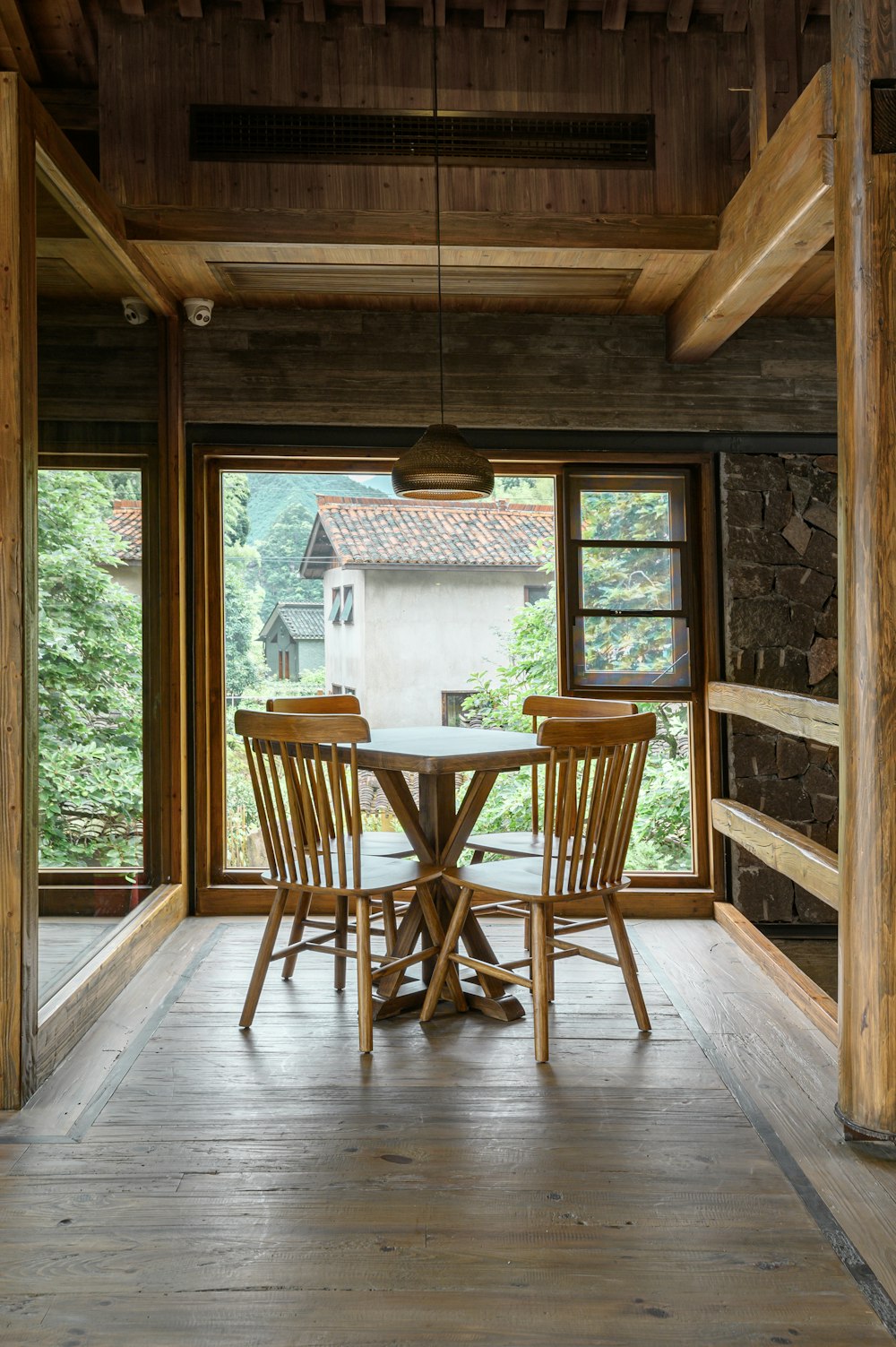 brauner Holztisch und Stühle in der Nähe des Fensters