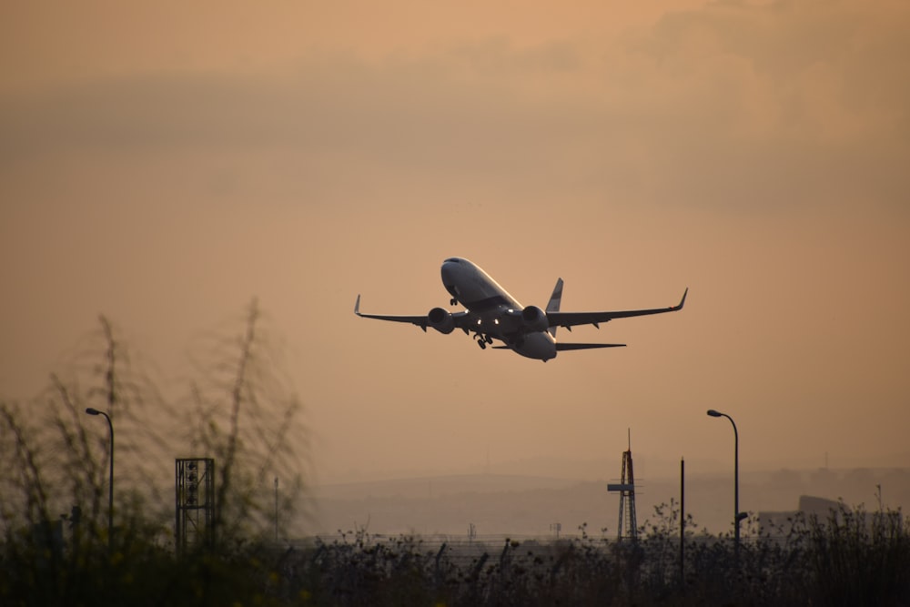 aeroplano bianco che vola sopra le nuvole durante il giorno