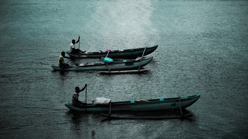 2 person riding on green boat on body of water during daytime