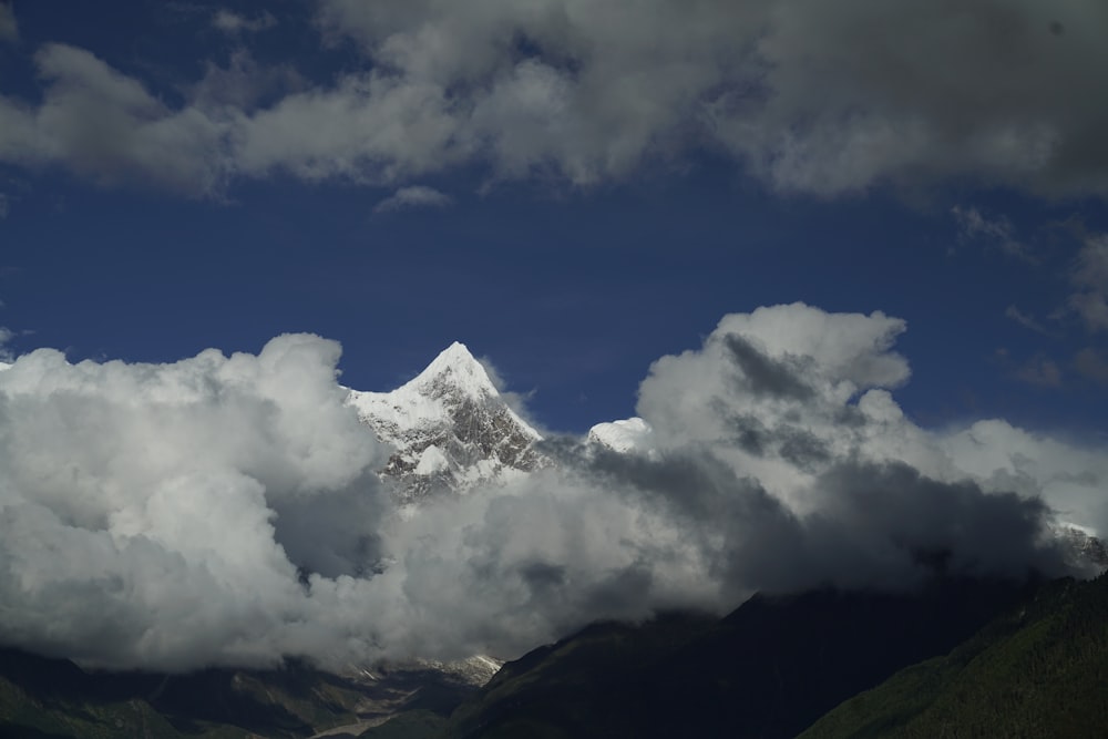 white clouds over green mountain