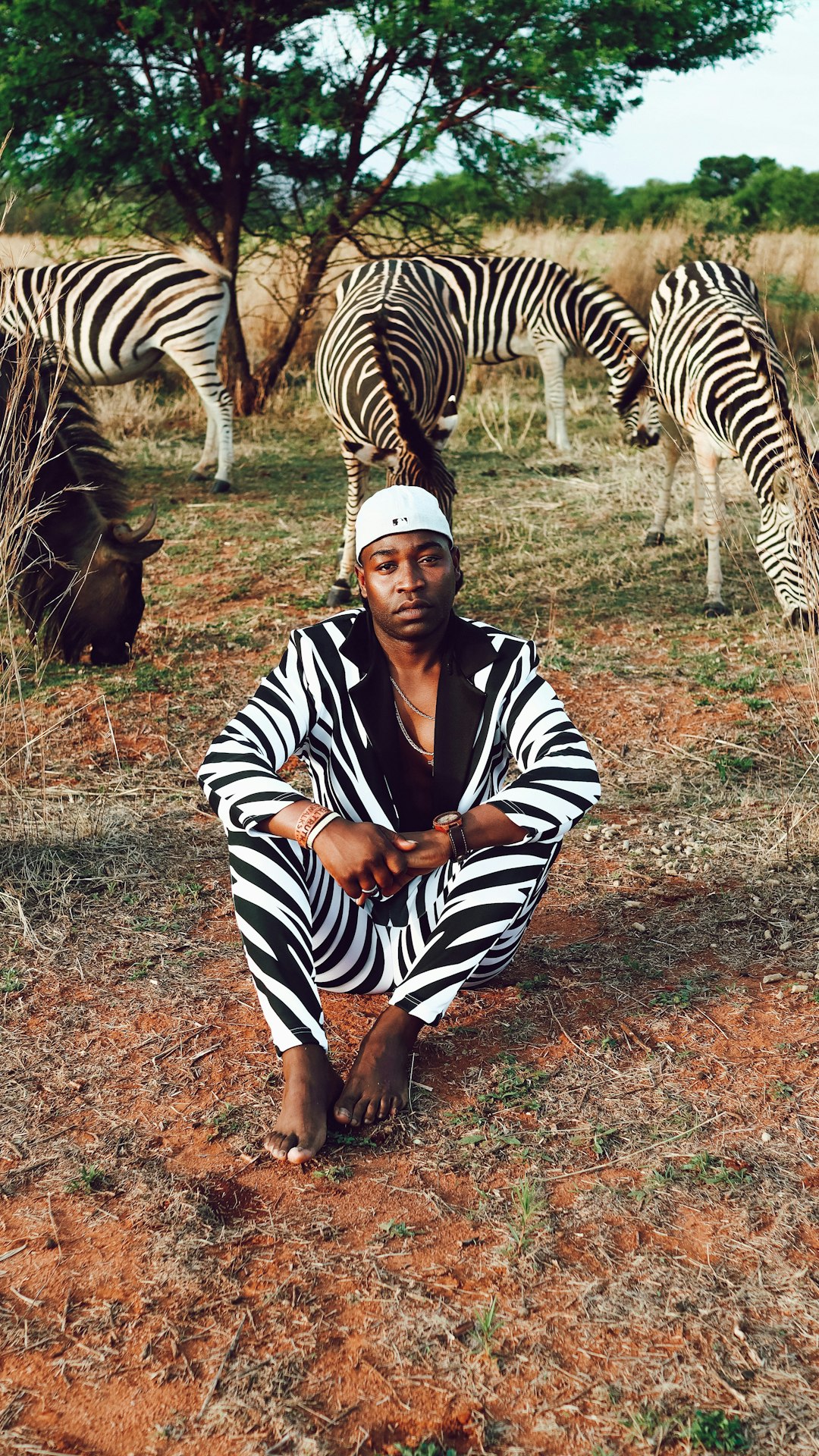 woman in black and white stripe long sleeve shirt standing beside zebra during daytime