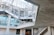 An industrial-looking architectural structure with metal beams and walkways. The design incorporates modern elements with glass windows and concrete walls. The building has various levels connected by metal stairs and pathways, creating an intricate, geometric pattern.