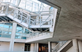 An industrial-looking architectural structure with metal beams and walkways. The design incorporates modern elements with glass windows and concrete walls. The building has various levels connected by metal stairs and pathways, creating an intricate, geometric pattern.