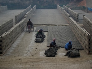 Wide view of a brick manufacturing facility with workers handling brick production.