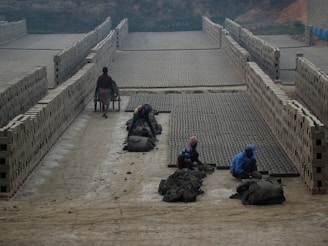 Skilled workers shaping clay bricks with precision in a modern factory.
