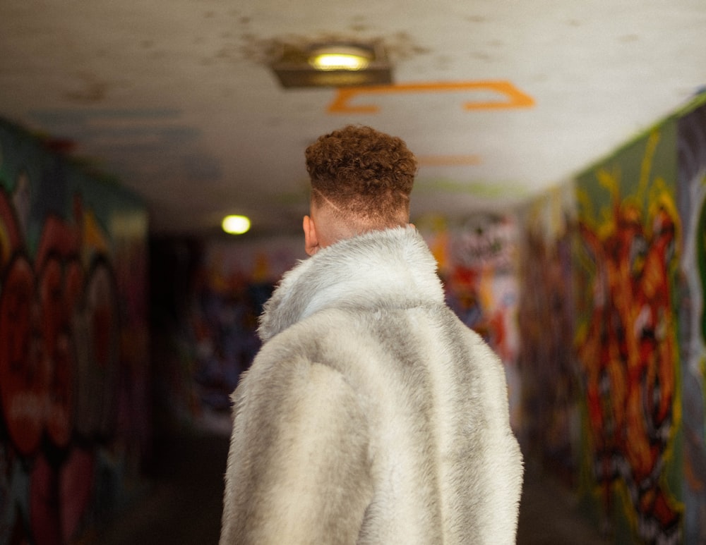 man in white fur coat standing