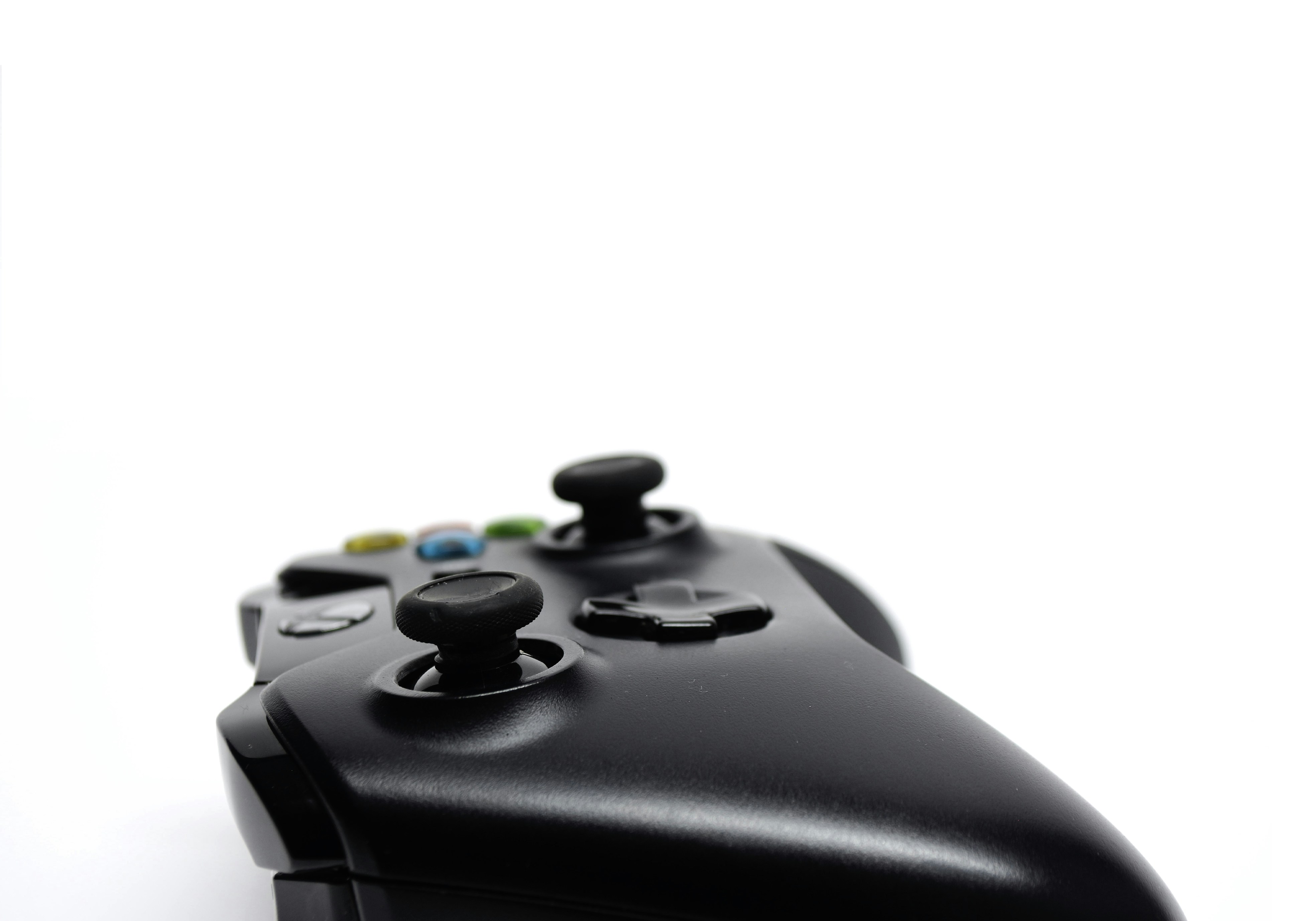 Black gaming controller with customizable buttons on a dark desk surface